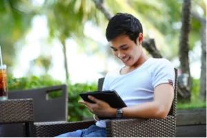 person working on a tablet, seated outdoors